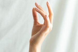 A graceful hand with pale pink polished nails.