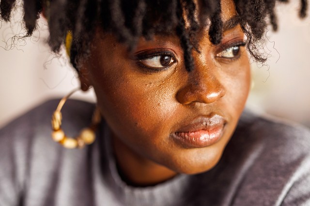 black woman with gold earrings looking away