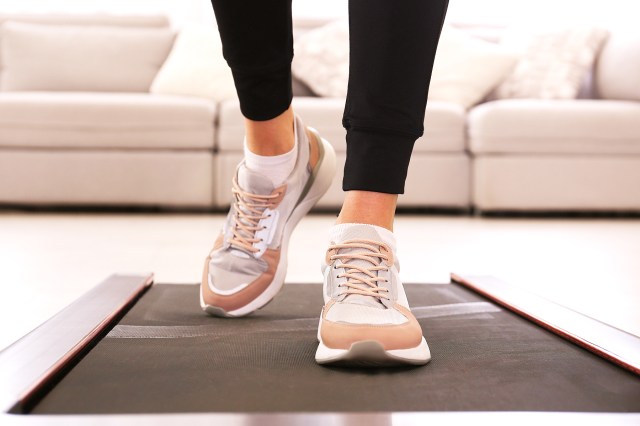 knees down with black leggings and sneakers on a walking pad