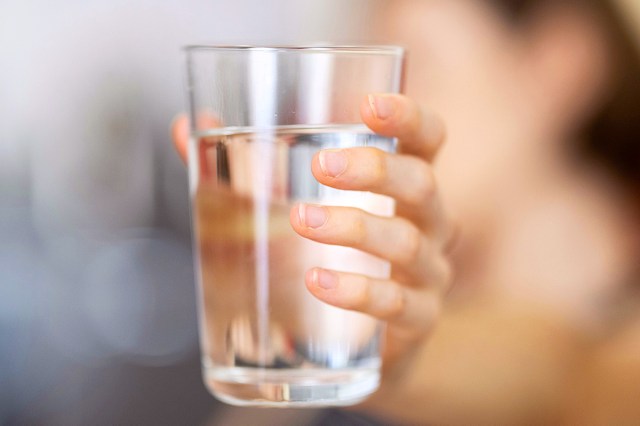 hand holding glass of water