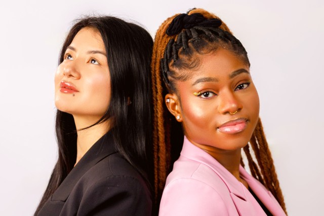 one asian woman wearing a black blazer and a black woman wearing a pink blazer