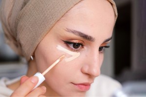 woman applying concealer under eyes