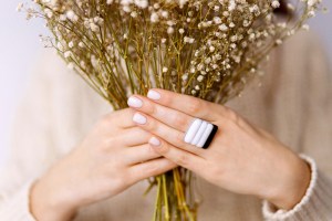 woman with white nails holding flowers