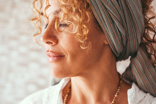 Side portrait of female people in meditation. Middle age pretty lady with closed eyes and peaceful feeling. Concept of happiness inside