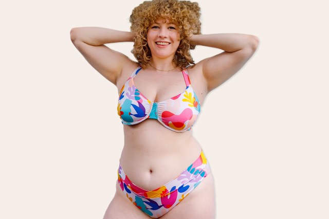 A blonde, curly haired woman in a colorful bikini