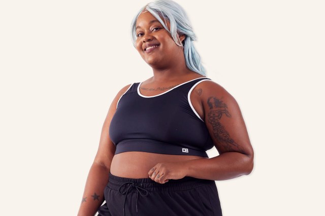 Black woman with grey hair wearing a sports bra top and black shorts
