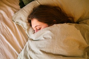 woman under a blanket in bed