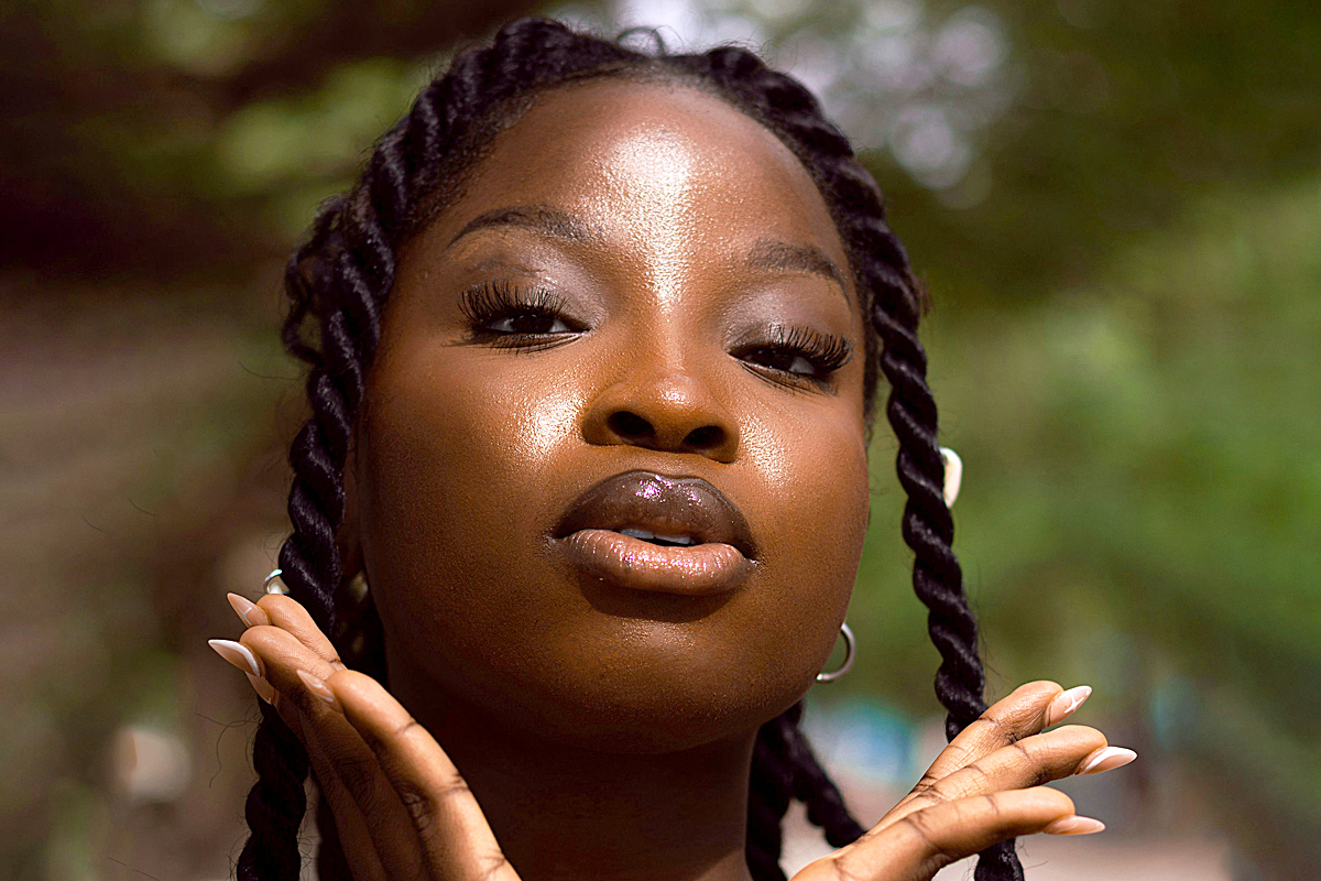 a woman with braids holding her hands together