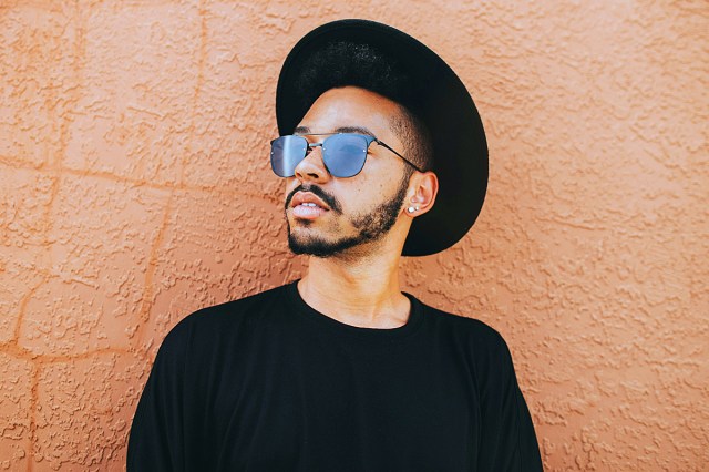 man leaning on brown wall