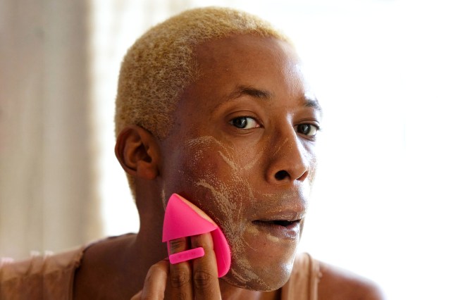 a man washing his face in front of a mirror