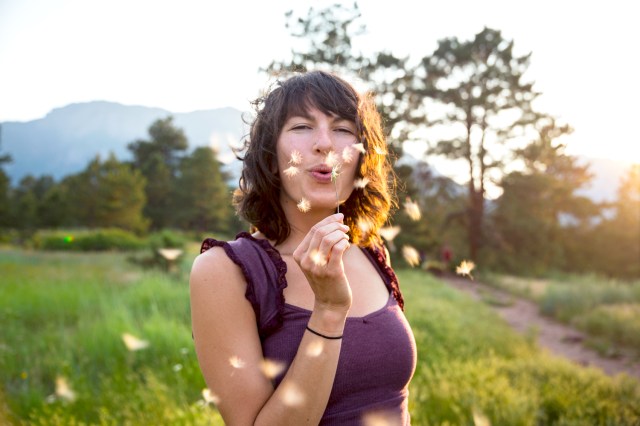 Woman blowing dandelion flower