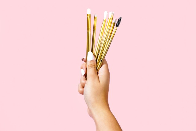 person holding makeup brushes