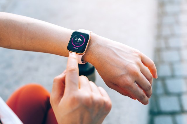 sports woman checks her fitness statistics on smartwatch to monitor her training progress