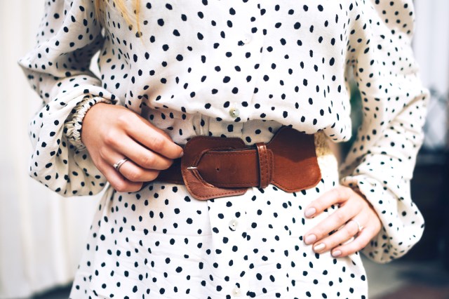 Cropped image of woman wearing black and white polka dot dress