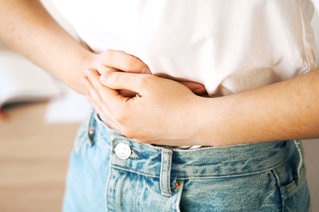 Sick girl hold abdomen because it hurts