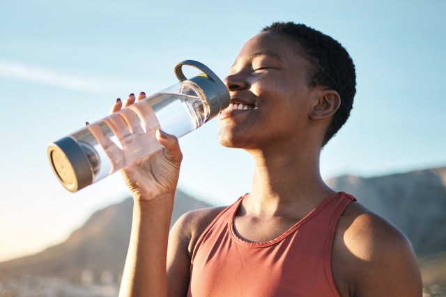 Woman drinking water from reusable water bottle