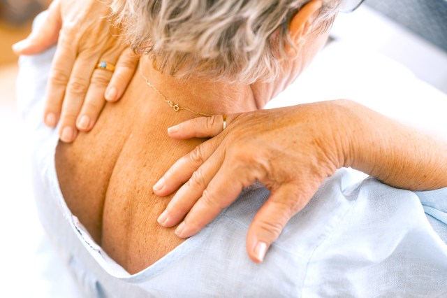 Senior woman massaging the pain in her neck