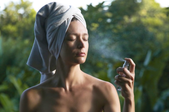 Woman spraying facial mist on her face