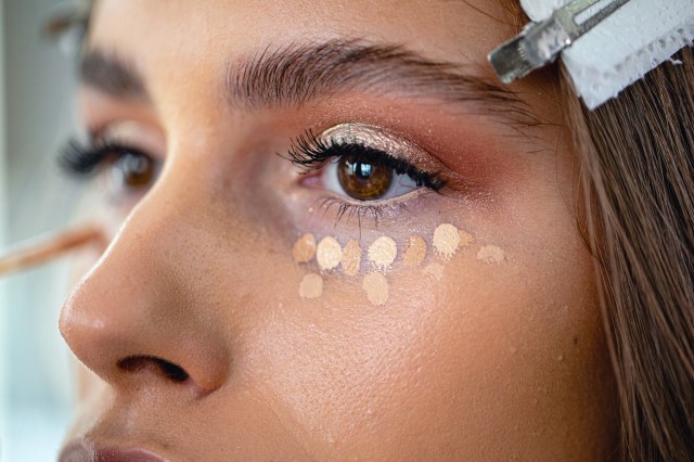 Professional model in a beauty salon enjoying getting makeup on