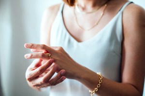 a woman putting on her jewelry