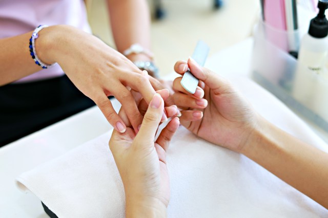 Female hands getting a manicure treatment in a nail salon