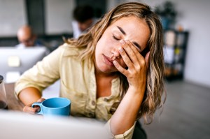 Tired woman rubbing her eyes