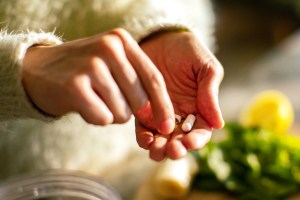 Person taking a health supplement in the kitchen