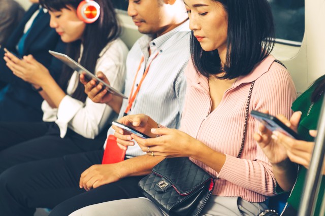 People using mobile phones in public underground train