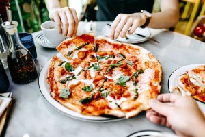 Close up of couple sharing slices of freshly made pizza