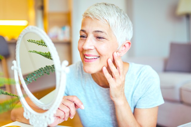 mature woman admiring herself in the mirror