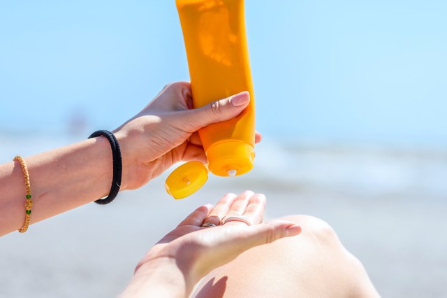 Hand squeezing sunscreen into palm