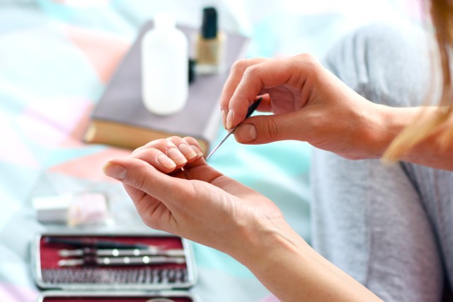 Woman giving herself a manicure at home