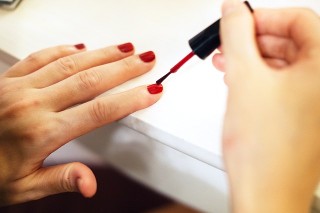 Woman painting her nails red