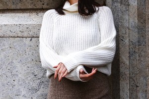 Cropped image of a woman wearing a white sweater