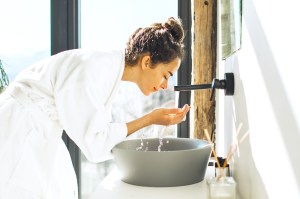 Woman washing her face in the sink