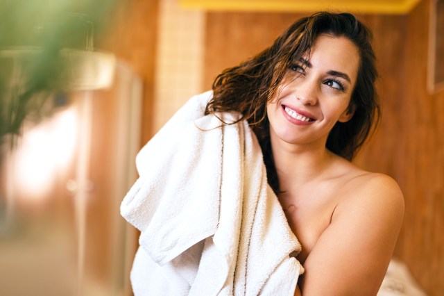 Woman drying wet hair after a shower