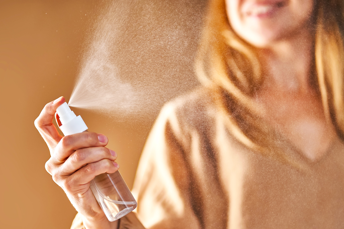 Woman spraying mist from a bottle