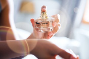 Close up of person spraying perfume from bottle onto wrist