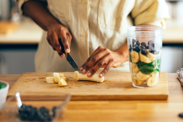 Close Up of Woman Hands Cutting Banana on a Cutting Board