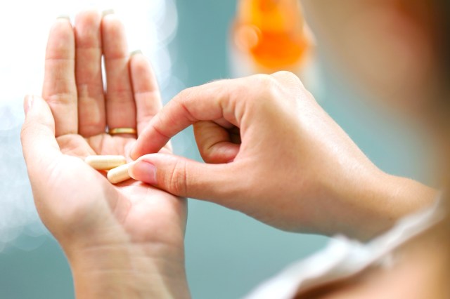 Close up of supplement pills in woman's hand