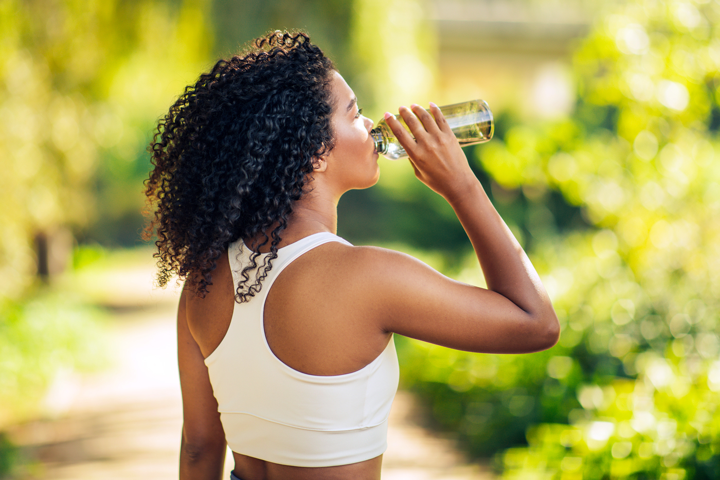 Woman drinking water bottle, outdoors