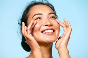 Beautiful smiling woman touching her face