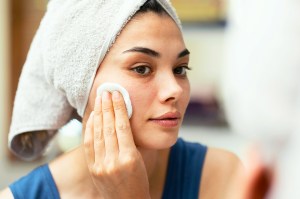 Woman using cotton round on her face