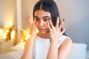 Woman applying cream under her eyes