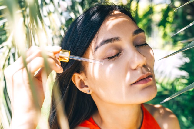 woman applying a dropper to her face